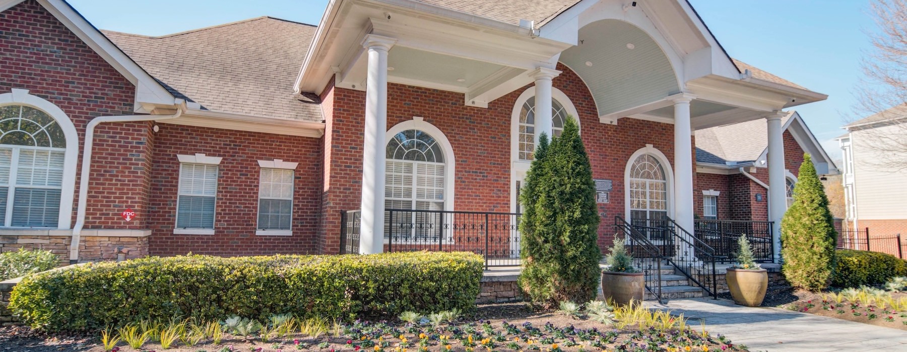 a brick building with a large front yard