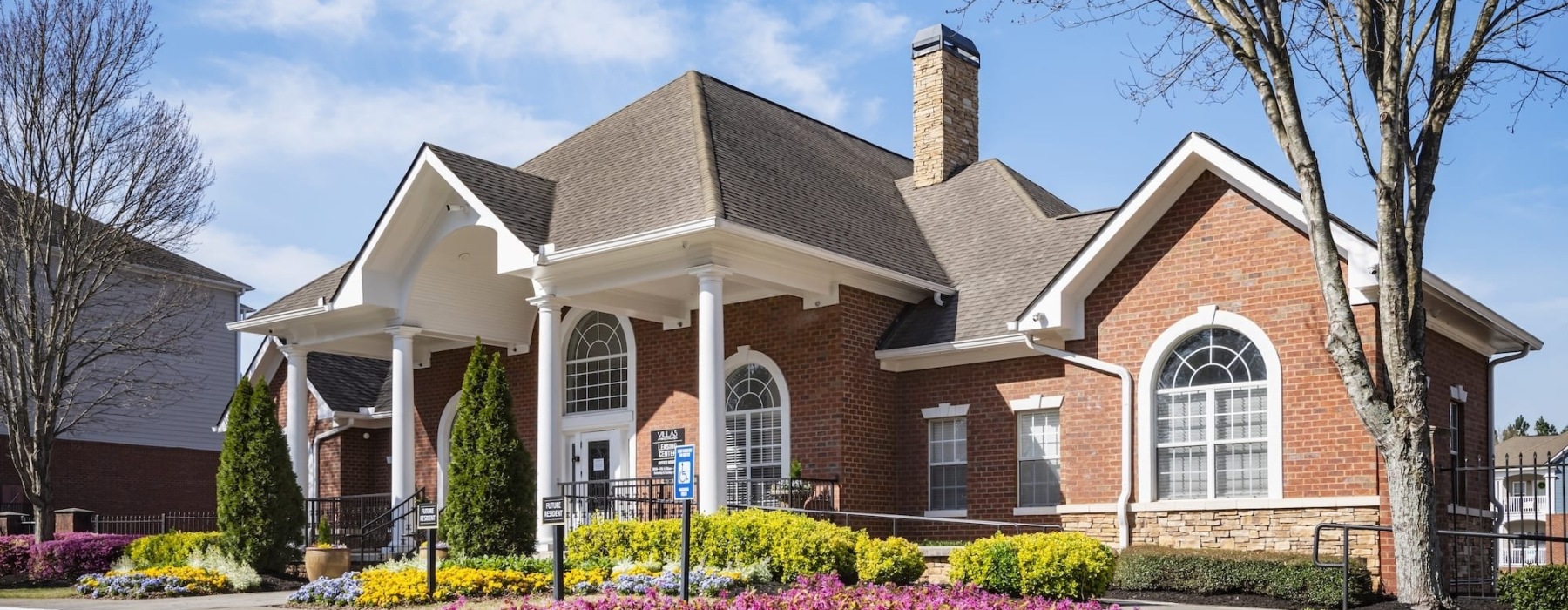 a brick building with a large front yard