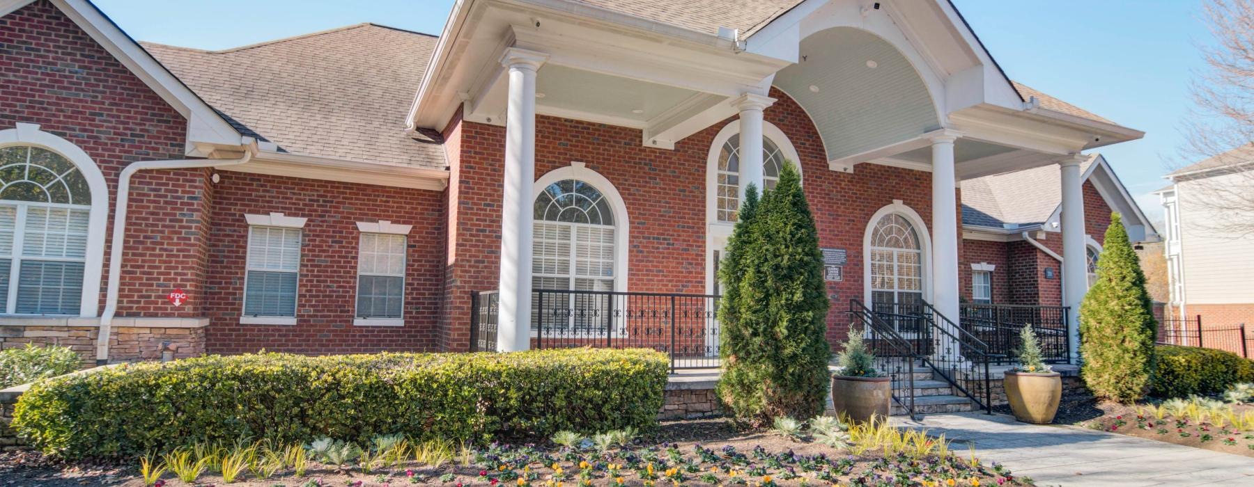 a brick building with a large front yard